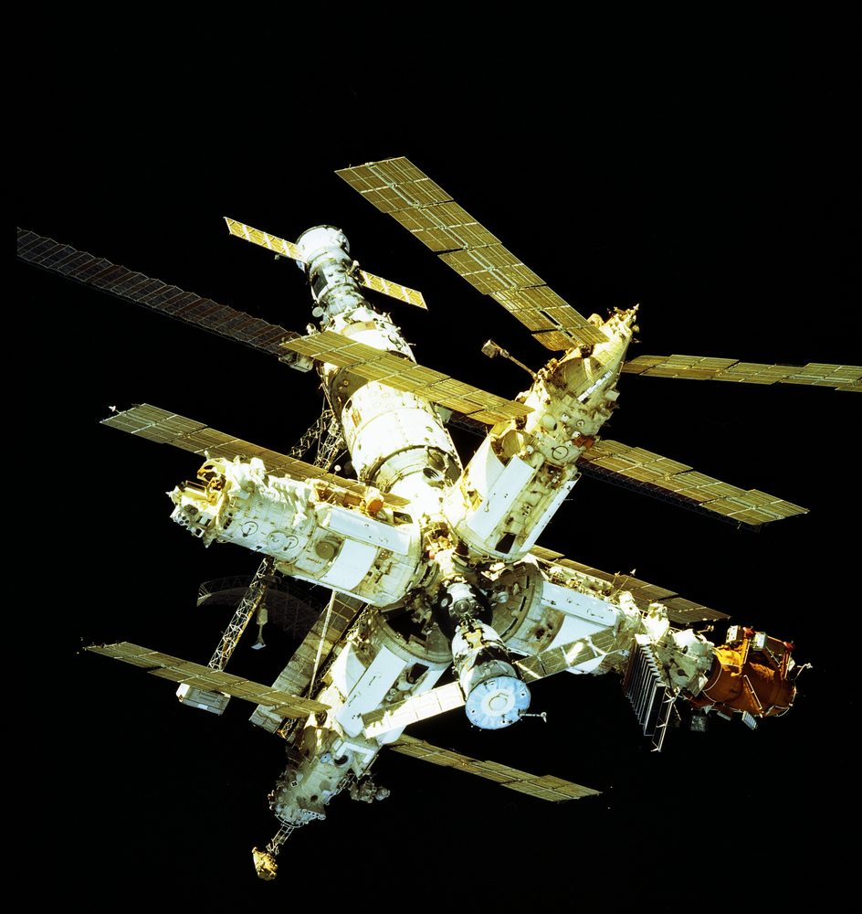 Cluster of white modules with solar arrays splayed at many angles against black space