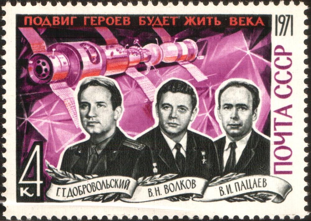 Three men in suits rendered in monochrome across a magenta and crimson stamp