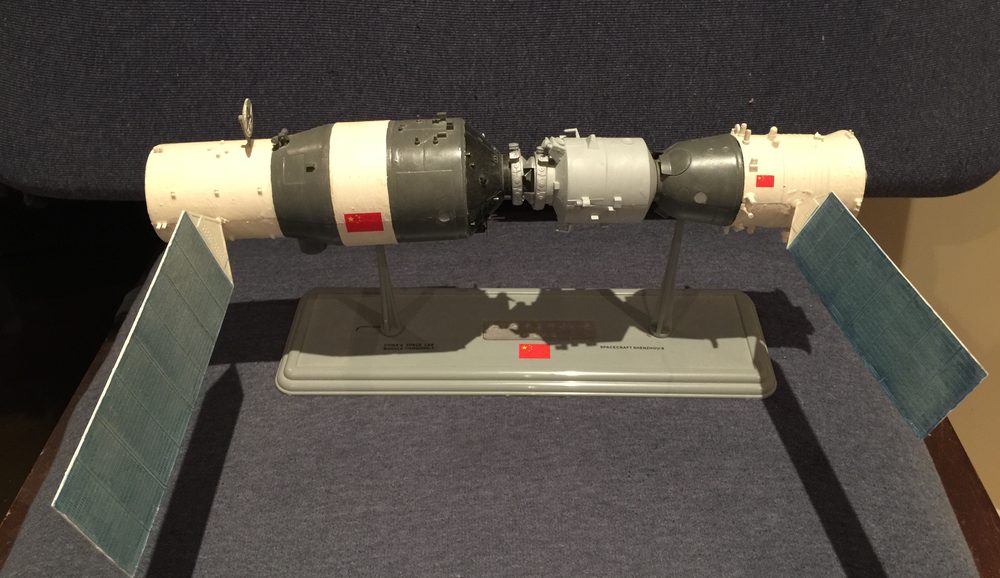 Desk-sized model on a stand, two cylinders joined end to end with flat solar panels