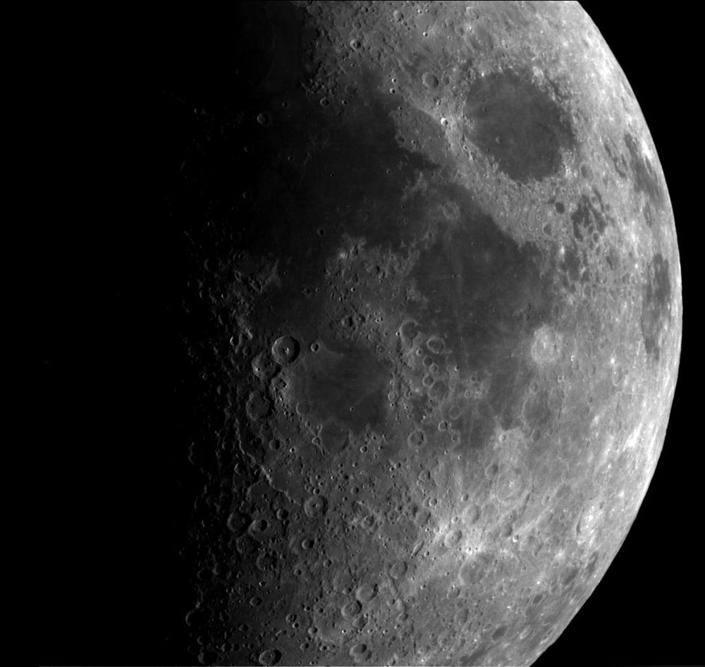 Monochrome lunar disc, the terminator down the left, craters crowding the shadowed edge