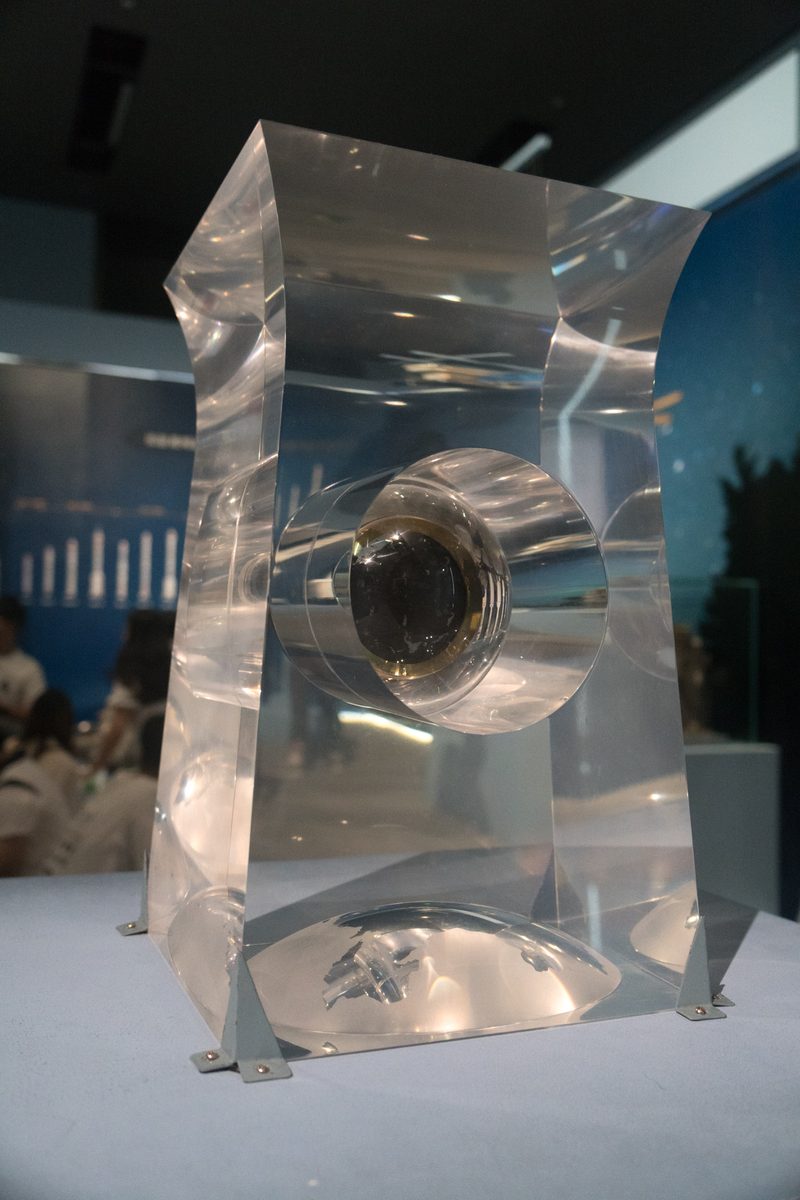 Clear acrylic display block on a plinth, a round window holding dark grains