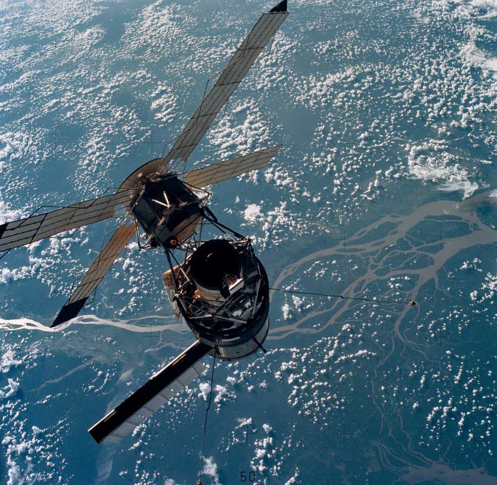 The station above a braided river delta, windmill arrays above and one long panel below